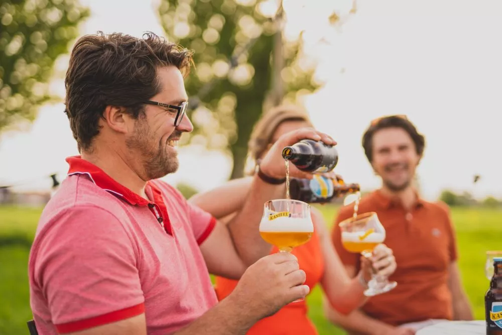 Kasteelbier uitgeschonken in het iconische bierglas van Kasteel, een biermerk gebrouwen door Kasteel Brouwerij Vanhonsebrouck - een Belgische brouwerij uit Izegem met een rijke traditie in het innoveren.