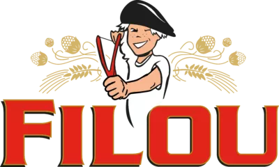 Logo van Filou met een lachende jongeman die knipoogt, in een wit T-shirt met zwarte baret op het hoofd, en een katapult vasthoudt, met daarachter gouden hopbloemen en de merknaam “FILOU” in grote rode letters.